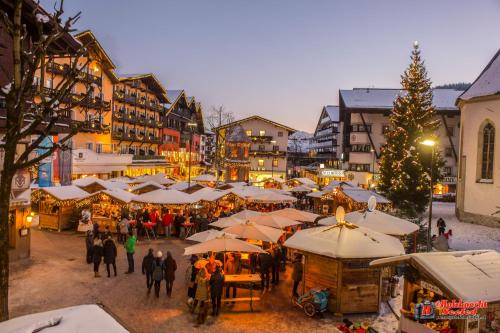 um grupo de pessoas andando em torno de um mercado de Natal em Das Aparthotel Olympia Tirol em Seefeld no Tirol