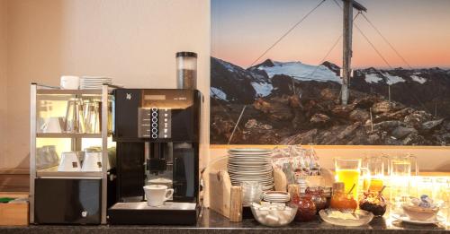 a kitchen with a coffee maker and a microwave at Apart Hotel Arno in Sölden