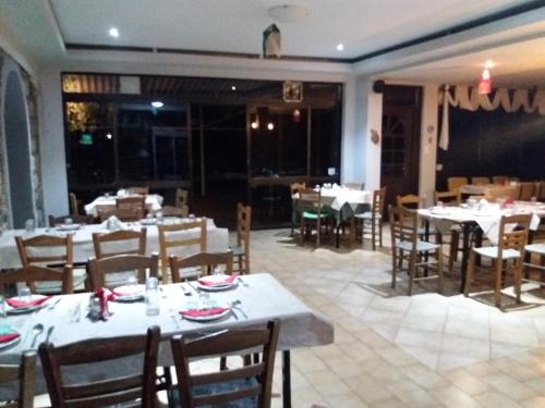 a dining room with tables and chairs in a restaurant at Manoleas Rooms to Let in Leonidio