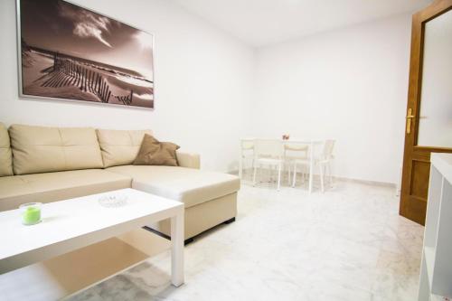 a living room with a couch and a table at Apartamentos Centro 1 El Puerto de Santa Maria in El Puerto de Santa María