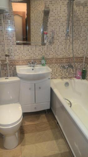 een badkamer met een toilet, een wastafel en een bad bij Apartment on Kizhevatova 10 in Penza