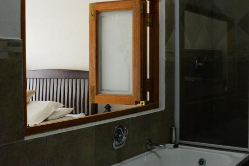 a bathroom with a mirror and a sink and a tub at Avant Garde Lodge in Kempton Park
