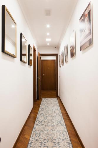 a hallway with a rug on the floor and pictures on the walls at Isa Guest Rooms in Naples