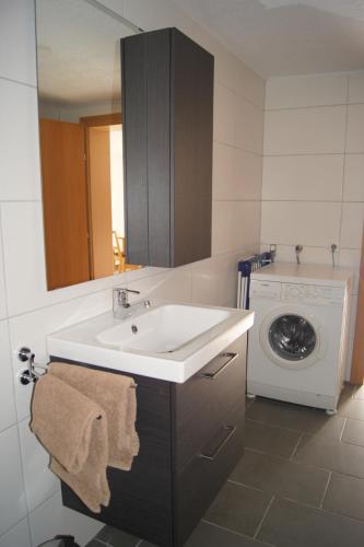 a bathroom with a sink and a washing machine at Gästehaus Alberta in Navis