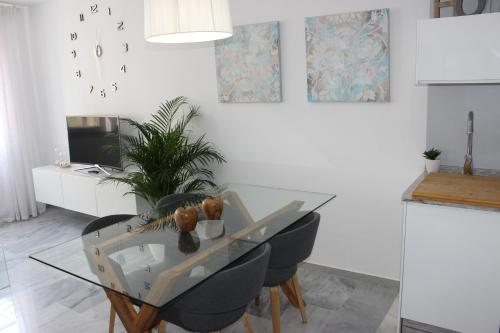 comedor con mesa de cristal y sillas en Atarazana Apartment, en Málaga