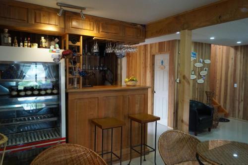a bar with two stools in a room with wood at Hostal Eifelhaus in Pucón