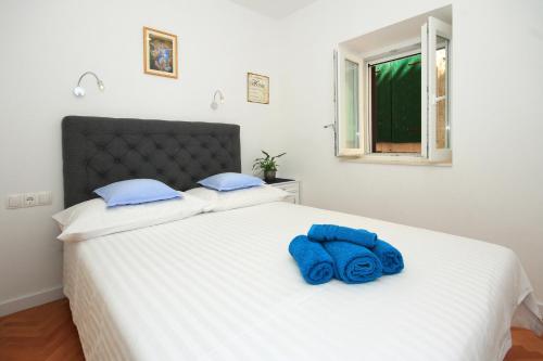 een blauwe handdoek bovenop een wit bed bij Apartment Zorica in Omiš