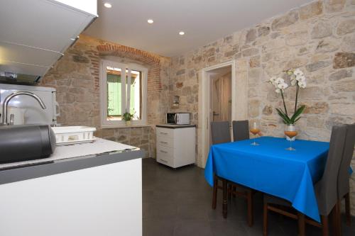 een keuken met een tafel met een blauwe tafeldoek bij Apartment Zorica in Omiš