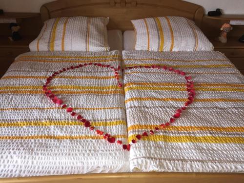 a heart made out of beads on a bed at Komfortable Apartments in der Villa Eule in Varel