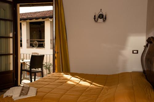 - une chambre avec un lit, une table et une fenêtre dans l'établissement La Madonnina Agriturismo Dorè, à Alba