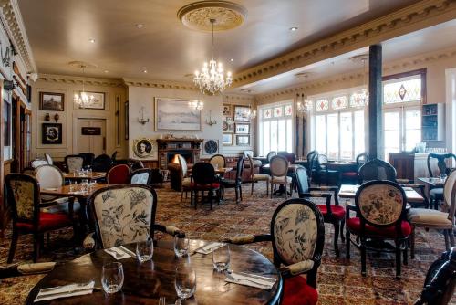 a restaurant with tables and chairs and a chandelier at The Duke Of Marlborough in Russell
