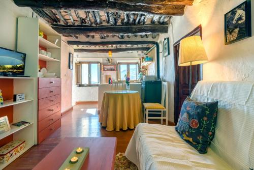 a living room with a table and a kitchen at Casa Amaranta in Capileira