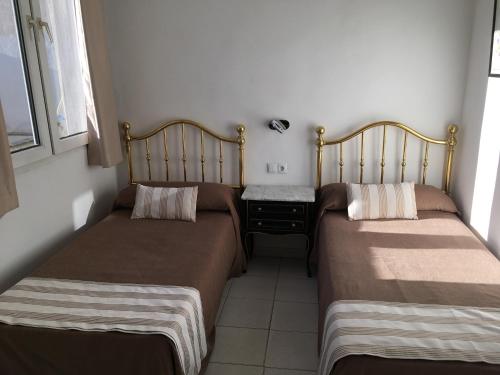 two beds in a small room with a table at Hotel Marítimo Urban in Alicante