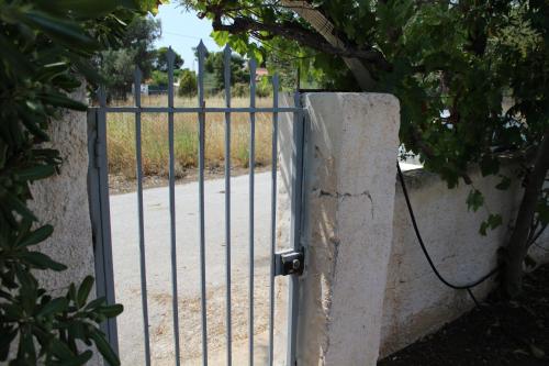 a gate with a rope attached to a fence at Surfers' Cottage in Anavissos