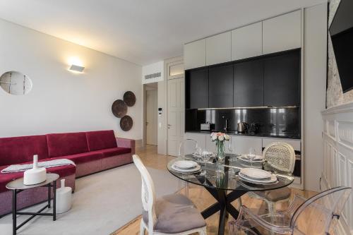 a living room with a red couch and a glass table at Santa Catarina Apartments in Porto