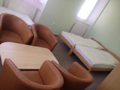 a room with two chairs and a table and a bed at Pension Žacléřský Medvěd in Žacléř