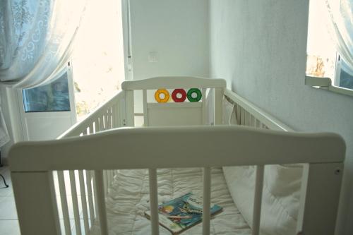 a white crib in a room with a window at Os 5 Sentidos in Mourão