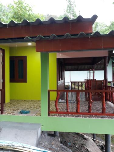 a house with a yellow and green wall at Easy Life Bungalows in Haad Yao