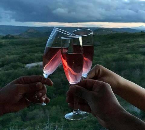 two people holding up a glass of wine at Pousada Vale Encantado in Serra de São Bento