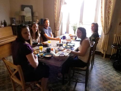 a group of people sitting around a table eating at La Grange en Champagne in Hermonville