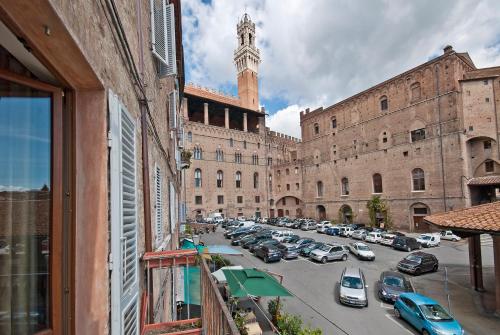 a large building with cars parked in a parking lot at Al Mercato B&B in Siena