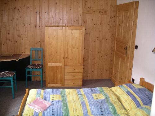 a bedroom with a bed and a wooden wall at Pension 48 in Špindlerův Mlýn
