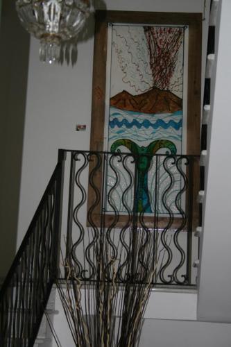 a staircase with a wrought iron railing and a stained glass window at B&B Mini Hotel Incity-close train station and port- in Salerno