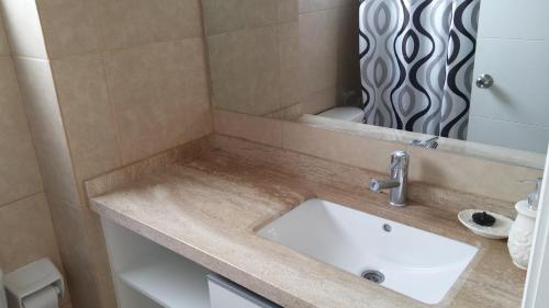 y baño con lavabo y espejo. en Condominio Costamar, en Coquimbo