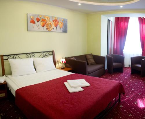 Cette chambre d'hôtel dispose d'un lit avec un couvre-lit rouge. dans l'établissement Apartments Deluxe, à Ivano-Frankivsk