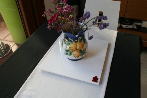 a vase with flowers in it sitting on a table at B&B Mini Hotel Incity-close train station and port- in Salerno