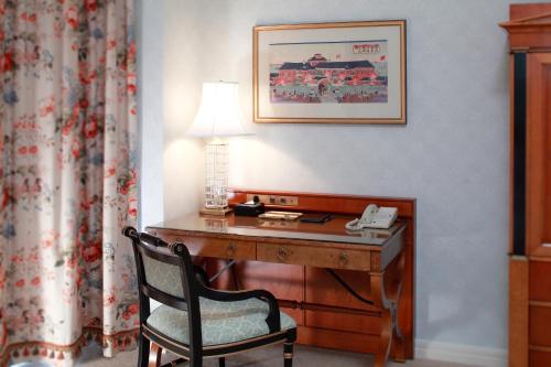 a desk in a hotel room with a lamp and a chair at Hotel Chinzanso Tokyo in Tokyo