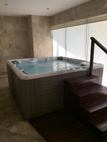 bañera de hidromasaje grande en una habitación con ventana en Bay View Grand Marina 203 - Sur, en Ixtapa