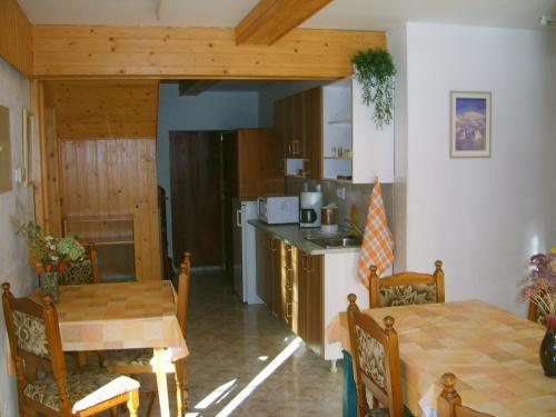 una cucina e una sala da pranzo con tavolo e sedie di Pension 48 a Špindlerův Mlýn
