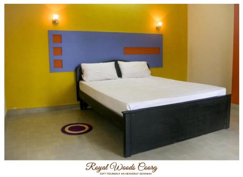 a bedroom with a bed with a blue and yellow wall at Royal Woods Coorg in Madikeri