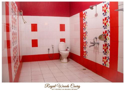 a bathroom with a toilet and red and white tiles at Royal Woods Coorg in Madikeri