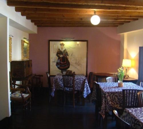 a dining room with two tables and a painting on the wall at Hotel-Hospedería los Templarios in Sepúlveda