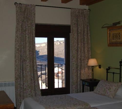 a bedroom with a bed and a window with a view at Hotel-Hospedería los Templarios in Sepúlveda