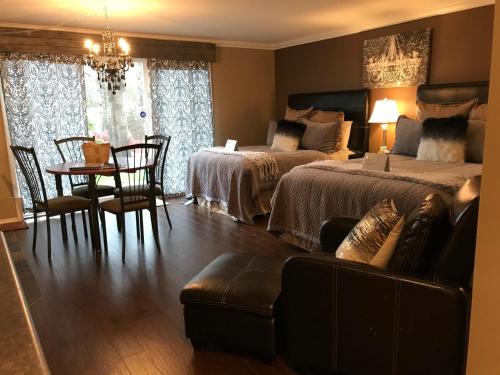 a bedroom with two beds and a table and a couch at Evergreen Bed & Breakfast in Hope
