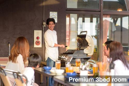 a man standing in a kitchen preparing food at El Sol Town Okinawa in Chatan