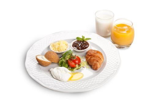 a plate of breakfast food with eggs bread and croissants at Boutique Hotel Traditional in Astana