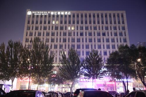 a tall building with cars parked in front of it at Metropolo Shenyang Wanda Plaza-Beiyi Road in Shenyang