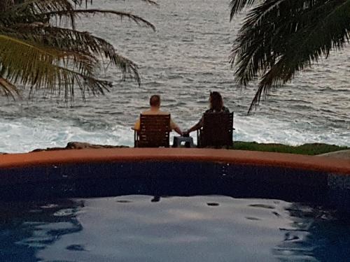 a man and woman sitting in chairs by the ocean at Villa Lucky Star in Tangalle