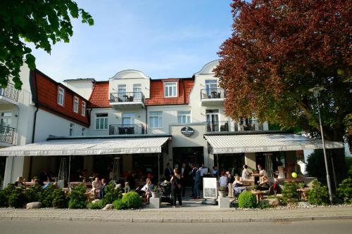 a group of people sitting outside of a building at Hotel Max am Meer Kühlungsborn in Kühlungsborn