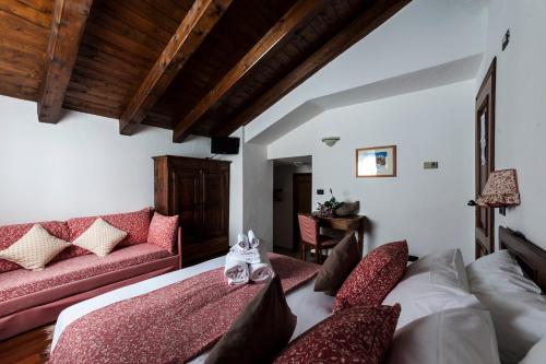 a living room with a bed and a couch at Hotel Baita Cretaz in Breuil-Cervinia