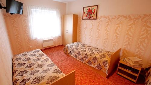a hotel room with two beds and a window at Armenia in Garliava