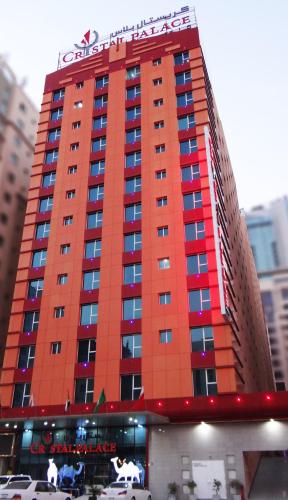 a red building with a sign on top of it at Crystal Palace Hotel in Manama