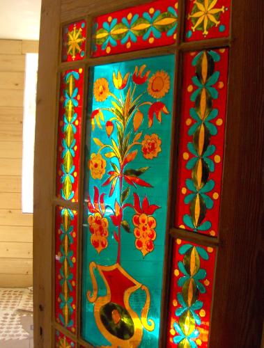 a colorful glass door with flowers painted on it at Ezera Maja in Liepāja