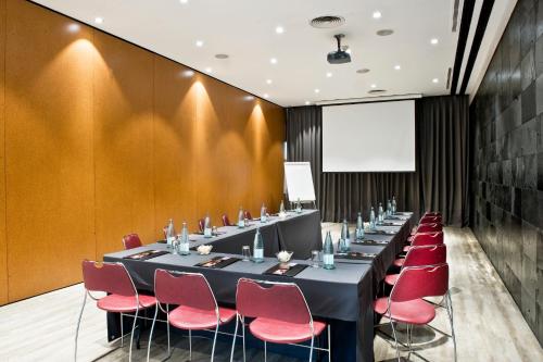 a conference room with a long table and red chairs at Best Western Plus Hotel Alfa Aeropuerto in Barcelona