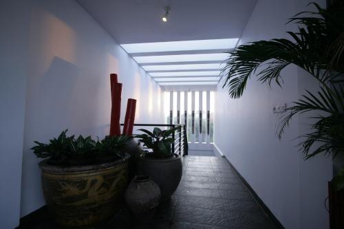 a hallway with potted plants and a ceiling at Kamar Kamar Boutique Hotel in Seminyak