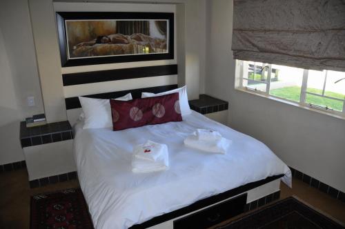 a bedroom with a bed with two dishes on it at Hadassa Guest House in Otjiwarongo